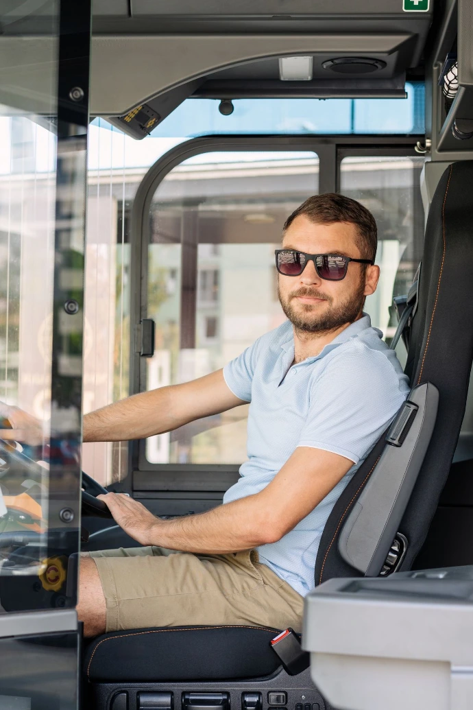 Man Driving Bus in the City on Sunny Day